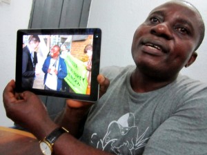 Ogoni Solidarity Forum director Celestine Akpobari showing picture with former Shell CEO Peter Voser - packed